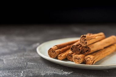 Seylan tarçın. Tarçın ahşap bir zemine yapışır. Tarçın rulosu ve pudra. Fırın, tatlı ve içecekler için baharatlı baharat. Güzel kokulu tarçın. Yakın plan. Mesaj için yer. Boşluğu kopyala