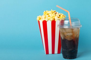 Kova içinde lezzetli patlamış mısır ve sinema biletli soğuk kola içecekler, renkli arka planda üç boyutlu gözlük. Sinema konsepti. Film izliyorum. Mesaj için yer var. Boşluğu kopyala