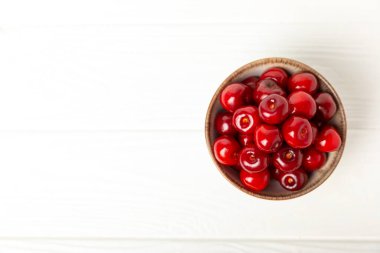 Kirazlar. Ahşap kaplamalı taze kirazlar ve yapraklar. Taze organik kiraz yığını. Böğürtlen ve meyve. Vejetaryen. Sağlıklı beslenme. Mesaj için yer. Boşluğu kopyala