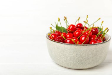 Kirazlar. Ahşap kaplamalı taze kirazlar ve yapraklar. Taze organik kiraz yığını. Böğürtlen ve meyve. Vejetaryen. Sağlıklı beslenme. Mesaj için yer. Boşluğu kopyala