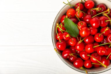 Kirazlar. Ahşap kaplamalı taze kirazlar ve yapraklar. Taze organik kiraz yığını. Böğürtlen ve meyve. Vejetaryen. Sağlıklı beslenme. Mesaj için yer. Boşluğu kopyala