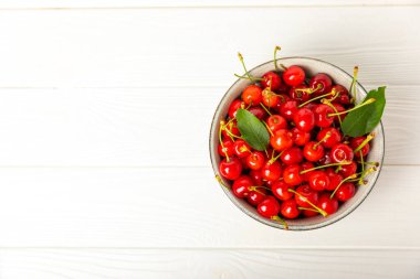 Kirazlar. Ahşap kaplamalı taze kirazlar ve yapraklar. Taze organik kiraz yığını. Böğürtlen ve meyve. Vejetaryen. Sağlıklı beslenme. Mesaj için yer. Boşluğu kopyala