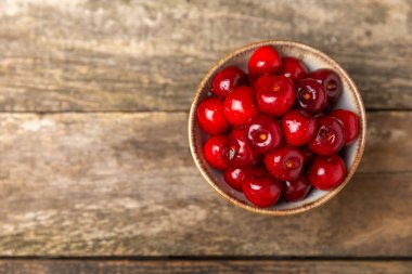 Kirazlar. Ahşap kaplamalı taze kirazlar ve yapraklar. Taze organik kiraz yığını. Böğürtlen ve meyve. Vejetaryen. Sağlıklı beslenme. Mesaj için yer. Boşluğu kopyala