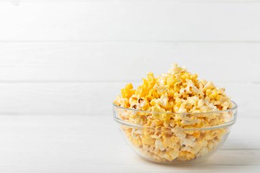 Tahta arka planda lezzetli patlamış mısır. Sinema ve eğlence anlayışı. Patlamış mısırlı film gecesi. Peynir ve patlamış mısır. Lezzetli aperatif, aperatif. Mesaj için yer. Uzayı kopyala. Banner