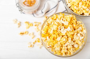 Tahta arka planda lezzetli patlamış mısır. Sinema ve eğlence anlayışı. Patlamış mısırlı film gecesi. Peynir ve patlamış mısır. Lezzetli aperatif, aperatif. Mesaj için yer. Uzayı kopyala. Banner