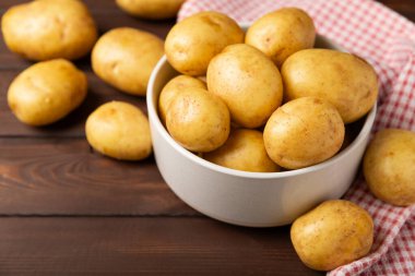 Genç patatesler Tahta zeminde taze patates. Hasat koleksiyonu. organik, taze kazılmış patatesler. Tarım geçmişi. Vejetaryen. Sebzeler. Mesajlar için yer. Boşluğu kopyala