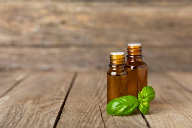 Ahşap kaplamalı fesleğen yağı. Fesleğen yağı ve taze yapraklar. Aromaterapi. Aroma yağı. Şifalı bitkiler. Alternatif tıp. Mesaj için yer. Boşluğu kopyala.