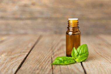 Ahşap kaplamalı fesleğen yağı. Fesleğen yağı ve taze yapraklar. Aromaterapi. Aroma yağı. Şifalı bitkiler. Alternatif tıp. Mesaj için yer. Boşluğu kopyala.