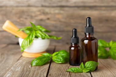 Ahşap kaplamalı fesleğen yağı. Fesleğen yağı ve taze yapraklar. Aromaterapi. Aroma yağı. Şifalı bitkiler. Alternatif tıp. Mesaj için yer. Boşluğu kopyala.