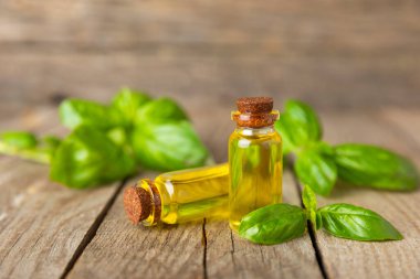 Ahşap kaplamalı fesleğen yağı. Fesleğen yağı ve taze yapraklar. Aromaterapi. Aroma yağı. Şifalı bitkiler. Alternatif tıp. Mesaj için yer. Boşluğu kopyala.