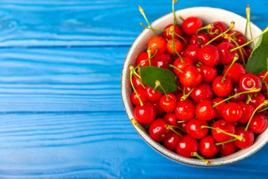 Kirazlar. Ahşap kaplamalı taze kirazlar ve yapraklar. Taze organik kiraz yığını. Böğürtlen ve meyve. Vejetaryen. Sağlıklı beslenme. Mesaj için yer. Boşluğu kopyala