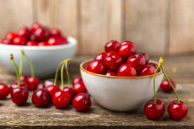 Kirazlar. Ahşap kaplamalı taze kirazlar ve yapraklar. Taze organik kiraz yığını. Böğürtlen ve meyve. Vejetaryen. Sağlıklı beslenme. Mesaj için yer. Boşluğu kopyala