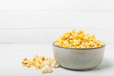 Ahşap arka planda lezzetli patlamış mısır. Sinema ve eğlence anlayışı. Patlamış mısırlı film gecesi. Peynir ve patlamış mısır. Lezzetli aperatif, aperatif. Mesaj için yer. Uzayı kopyala. Banner