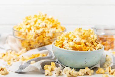 Ahşap arka planda lezzetli patlamış mısır. Sinema ve eğlence anlayışı. Patlamış mısırlı film gecesi. Peynir ve patlamış mısır. Lezzetli aperatif, aperatif. Mesaj için yer. Uzayı kopyala. Banner