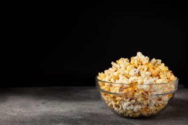 Ahşap arka planda lezzetli patlamış mısır. Sinema ve eğlence anlayışı. Patlamış mısırlı film gecesi. Peynir ve patlamış mısır. Lezzetli aperatif, aperatif. Mesaj için yer. Uzayı kopyala. Banner