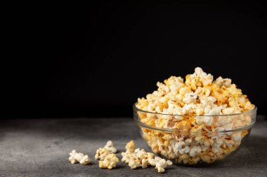 Ahşap arka planda lezzetli patlamış mısır. Sinema ve eğlence anlayışı. Patlamış mısırlı film gecesi. Peynir ve patlamış mısır. Lezzetli aperatif, aperatif. Mesaj için yer. Uzayı kopyala. Banner