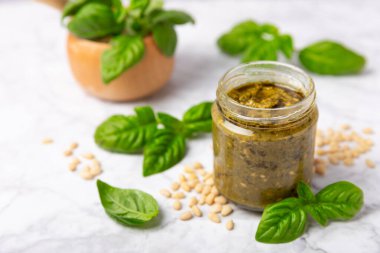 Pesto. Ahşap kaplamalı İtalyan fesleğen sosu. Pesto sosu içeriği: taze fesleğen, çam fıstığı, parmesan peyniri ve zeytinyağı. Metin için boşluk. Boşluğu kopyala.