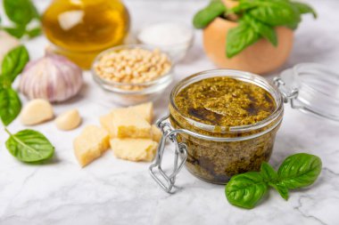 Pesto. Ahşap kaplamalı İtalyan fesleğen sosu. Pesto sosu içeriği: taze fesleğen, çam fıstığı, parmesan peyniri ve zeytinyağı. Metin için boşluk. Boşluğu kopyala.