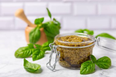 Pesto. Ahşap kaplamalı İtalyan fesleğen sosu. Pesto sosu içeriği: taze fesleğen, çam fıstığı, parmesan peyniri ve zeytinyağı. Metin için boşluk. Boşluğu kopyala.
