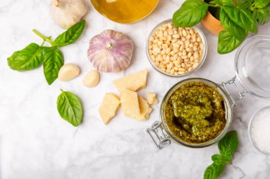 Pesto. Ahşap kaplamalı İtalyan fesleğen sosu. Pesto sosu içeriği: taze fesleğen, çam fıstığı, parmesan peyniri ve zeytinyağı. Metin için boşluk. Boşluğu kopyala.