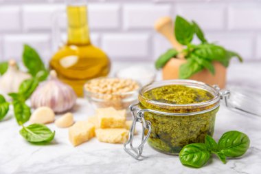 Pesto. Ahşap kaplamalı İtalyan fesleğen sosu. Pesto sosu içeriği: taze fesleğen, çam fıstığı, parmesan peyniri ve zeytinyağı. Metin için boşluk. Boşluğu kopyala.