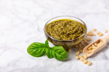 Pesto. Ahşap kaplamalı İtalyan fesleğen sosu. Pesto sosu içeriği: taze fesleğen, çam fıstığı, parmesan peyniri ve zeytinyağı. Metin için boşluk. Boşluğu kopyala.