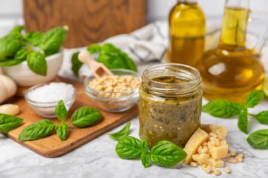 Pesto. Ahşap kaplamalı İtalyan fesleğen sosu. Pesto sosu içeriği: taze fesleğen, çam fıstığı, parmesan peyniri ve zeytinyağı. Metin için boşluk. Boşluğu kopyala.