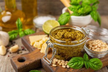 Pesto. Ahşap kaplamalı İtalyan fesleğen sosu. Pesto sosu içeriği: taze fesleğen, çam fıstığı, parmesan peyniri ve zeytinyağı. Metin için boşluk. Boşluğu kopyala.