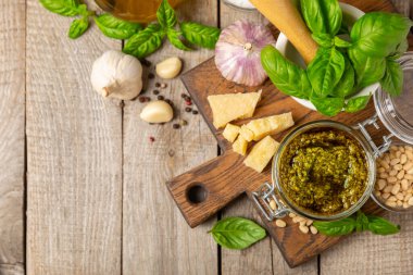 Pesto. Ahşap kaplamalı İtalyan fesleğen sosu. Pesto sosu içeriği: taze fesleğen, çam fıstığı, parmesan peyniri ve zeytinyağı. Metin için boşluk. Boşluğu kopyala.