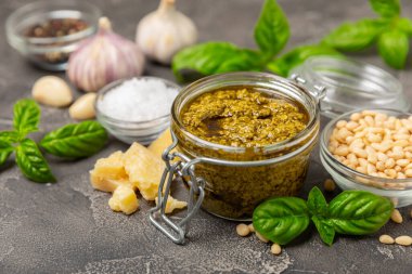 Pesto. Ahşap kaplamalı İtalyan fesleğen sosu. Pesto sosu içeriği: taze fesleğen, çam fıstığı, parmesan peyniri ve zeytinyağı. Metin için boşluk. Boşluğu kopyala.