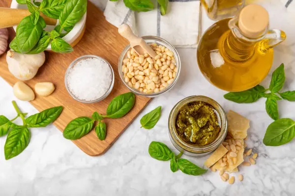 Pesto. Ahşap kaplamalı İtalyan fesleğen sosu. Pesto sosu içeriği: taze fesleğen, çam fıstığı, parmesan peyniri ve zeytinyağı. Metin için boşluk. Boşluğu kopyala.