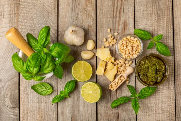 Pesto. Ahşap kaplamalı İtalyan fesleğen sosu. Pesto sosu içeriği: taze fesleğen, çam fıstığı, parmesan peyniri ve zeytinyağı. Metin için boşluk. Boşluğu kopyala.