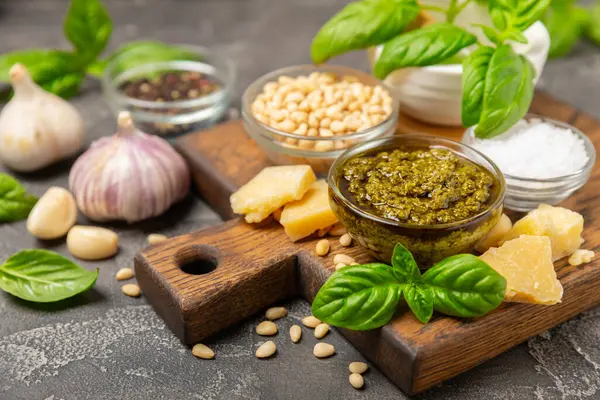 Pesto. Ahşap kaplamalı İtalyan fesleğen sosu. Pesto sosu içeriği: taze fesleğen, çam fıstığı, parmesan peyniri ve zeytinyağı. Metin için boşluk. Boşluğu kopyala.