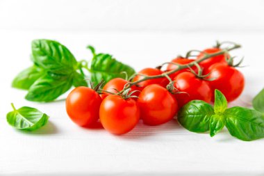 Taze vişneli domates ve dokulu taze yeşil fesleğen. Domates sosu. Vejetaryen. Salata için malzemeler. Organik yiyecekler. Mesaj için yer. Boşluğu kopyala.