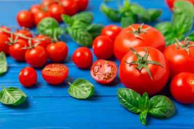 Taze vişneli domates ve dokulu taze yeşil fesleğen. Domates sosu. Vejetaryen. Salata için malzemeler. Organik yiyecekler. Mesaj için yer. Boşluğu kopyala.