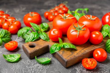 Taze vişneli domates ve dokulu taze yeşil fesleğen. Domates sosu. Vejetaryen. Salata için malzemeler. Organik yiyecekler. Mesaj için yer. Boşluğu kopyala.