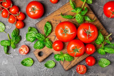 Taze vişneli domates ve dokulu taze yeşil fesleğen. Domates sosu. Vejetaryen. Salata için malzemeler. Organik yiyecekler. Mesaj için yer. Boşluğu kopyala.