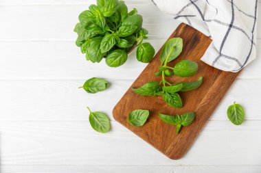 Ahşap kaplamalı yeşil fesleğen yaprakları. Mutfak otları, baharatlar. Taze yeşil organik fesleğen. Vejetaryen. Salata için yeşillik. Mesaj için yer. Boşluğu kopyala.