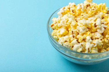 Arka planda bir kase tuzlanmış patlamış mısır. Sinema ve eğlence anlayışı. Patlamış mısırla film gecesi. Lezzetli aperatif, aperatif. Mesaj için yer. Uzayı kopyala Pankart