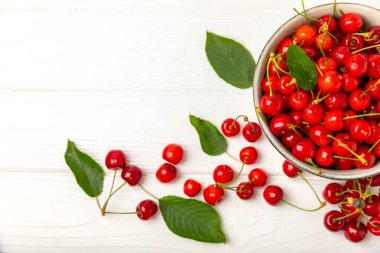 Kirazlar. Ahşap kaplamalı taze kirazlar ve yapraklar. Taze organik kiraz yığını. Böğürtlen ve meyve. Vejetaryen. Sağlıklı beslenme. Mesaj için yer. Boşluğu kopyala