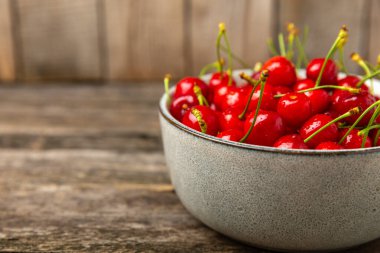 Kirazlar. Ahşap kaplamalı taze kirazlar ve yapraklar. Taze organik kiraz yığını. Böğürtlen ve meyve. Vejetaryen. Sağlıklı beslenme. Mesaj için yer. Boşluğu kopyala