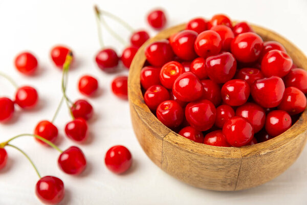 Cherries. Fresh ripe cherries with leaves on a textured wooden background. Fresh sweet organic cherry pile. Berries and fruits. Vegan. Healthy eating. Place for text. Copy space