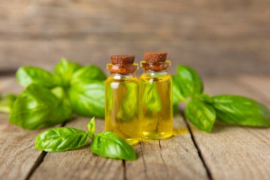 Ahşap kaplamalı fesleğen yağı. Fesleğen yağı ve taze yapraklar. Aromaterapi. Aroma yağı. Şifalı bitkiler. Alternatif tıp. Mesaj için yer. Boşluğu kopyala.