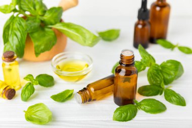 Ahşap kaplamalı fesleğen yağı. Fesleğen yağı ve taze yapraklar. Aromaterapi. Aroma yağı. Şifalı bitkiler. Alternatif tıp. Mesaj için yer. Boşluğu kopyala.