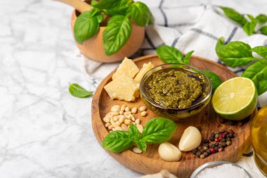 Pesto. Ahşap kaplamalı İtalyan fesleğen sosu. Pesto sosu içeriği: taze fesleğen, çam fıstığı, parmesan peyniri ve zeytinyağı. Metin için boşluk. Boşluğu kopyala.