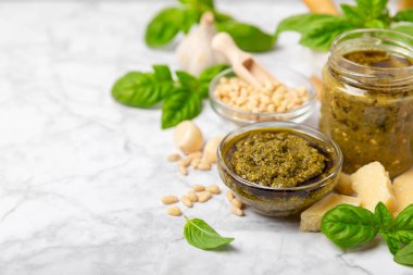 Pesto. Ahşap kaplamalı İtalyan fesleğen sosu. Pesto sosu içeriği: taze fesleğen, çam fıstığı, parmesan peyniri ve zeytinyağı. Metin için boşluk. Boşluğu kopyala.