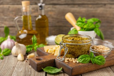 Pesto. Ahşap kaplamalı İtalyan fesleğen sosu. Pesto sosu içeriği: taze fesleğen, çam fıstığı, parmesan peyniri ve zeytinyağı. Metin için boşluk. Boşluğu kopyala.