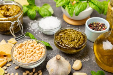 Pesto. Ahşap kaplamalı İtalyan fesleğen sosu. Pesto sosu içeriği: taze fesleğen, çam fıstığı, parmesan peyniri ve zeytinyağı. Metin için boşluk. Boşluğu kopyala.
