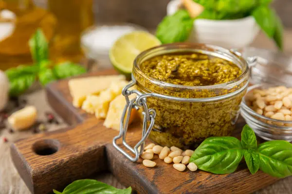 Pesto. Ahşap kaplamalı İtalyan fesleğen sosu. Pesto sosu içeriği: taze fesleğen, çam fıstığı, parmesan peyniri ve zeytinyağı. Metin için boşluk. Boşluğu kopyala.