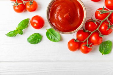 Domates ezmesi, sos, kâsede ketçap ve ahşap kaplamalı taze fesleğen yapraklı kiraz domatesleri. Vitaminler ve detoks diyeti. Sebze ve vejetaryen yemekleri. Mesaj için yer var. Boşluğu kopyala.